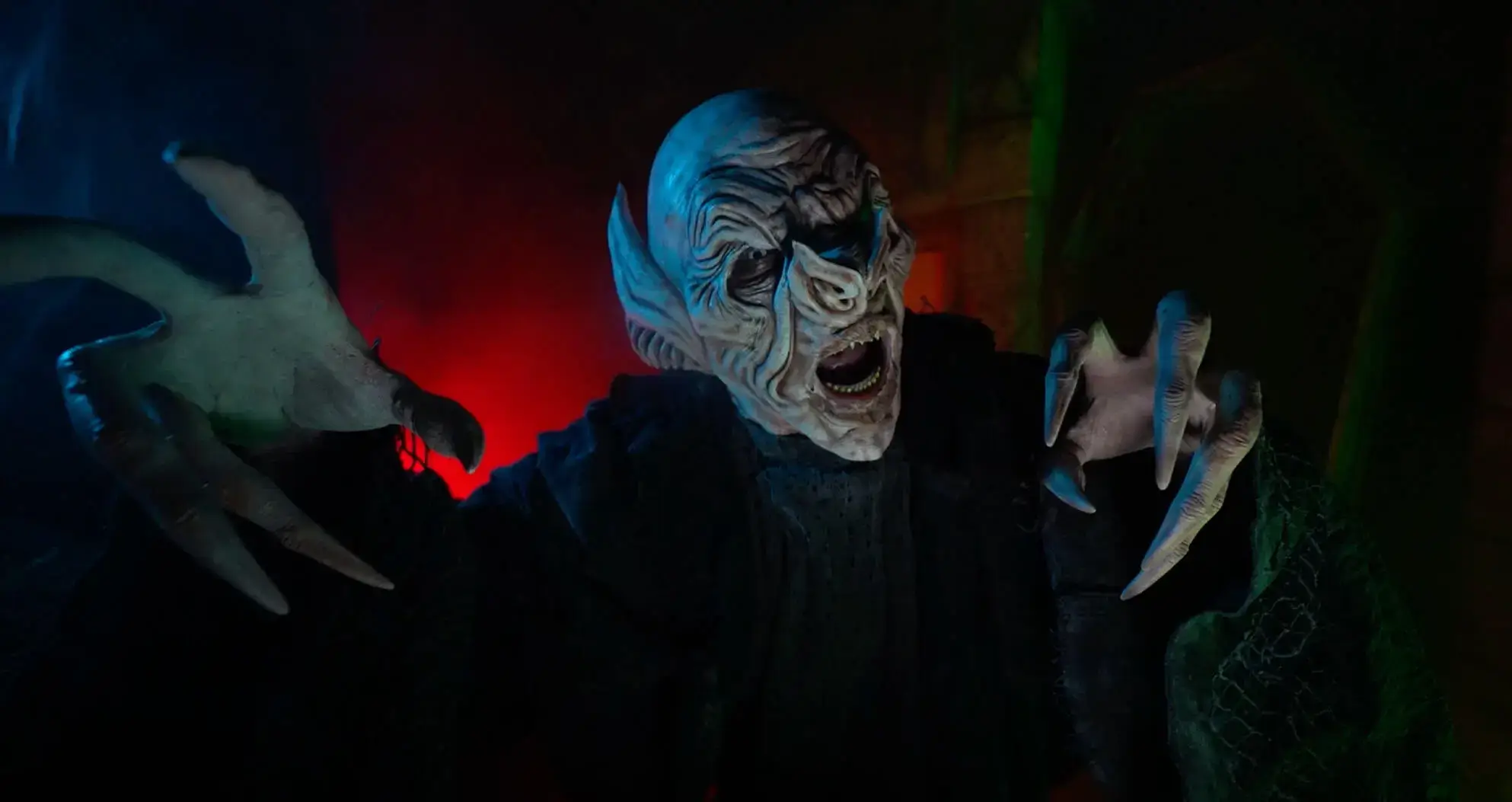 Blue demon actor roaring amid red fog at Atlanta haunted attraction Folklore
