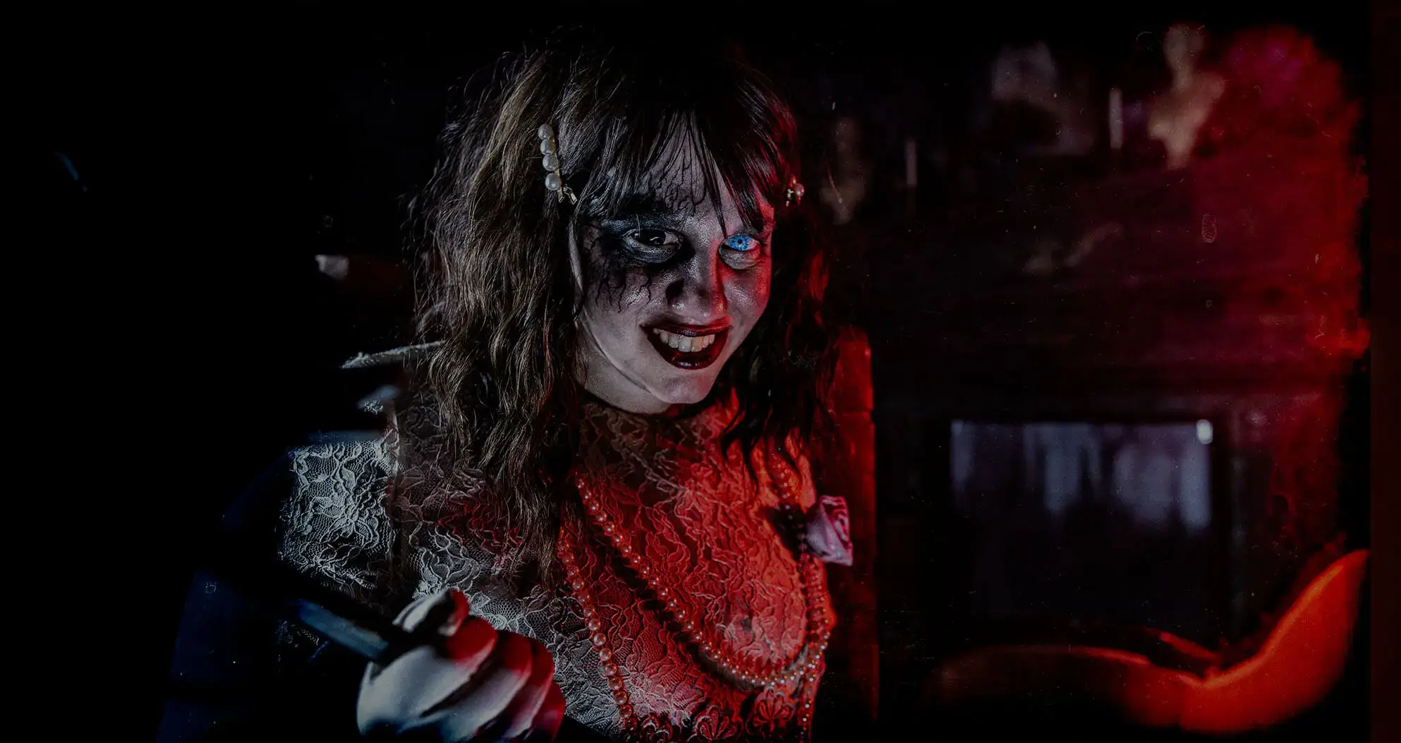 Creepy smiling actress in red at Folklore Haunted House GA